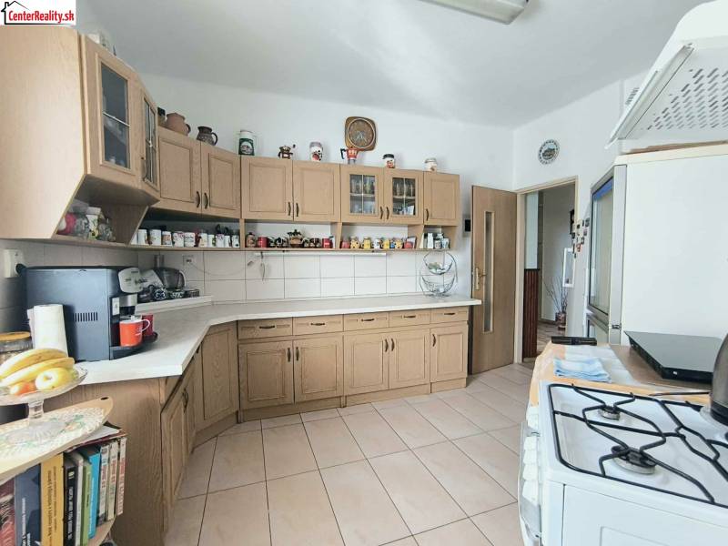 Küche in einem Einfamilienhaus mit Holzschränken und Keramikfliesen.