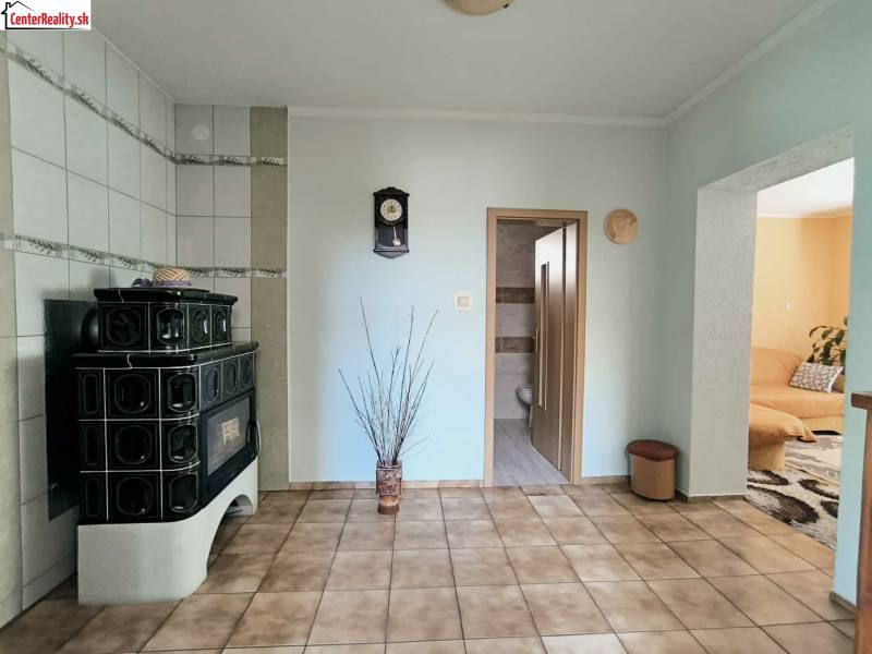 Innenraum eines Einfamilienhauses mit grünen Kacheln, einem Kachelofen und Fliesen.