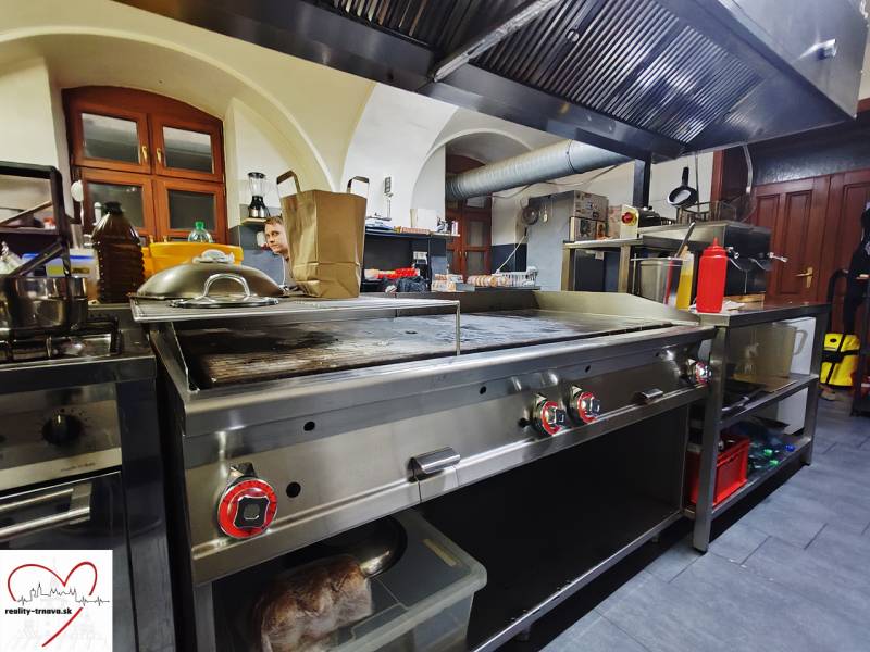 Küchen-Gastronomiebereiche mit Edelstahlausstattung und Dunstabzugshaube.