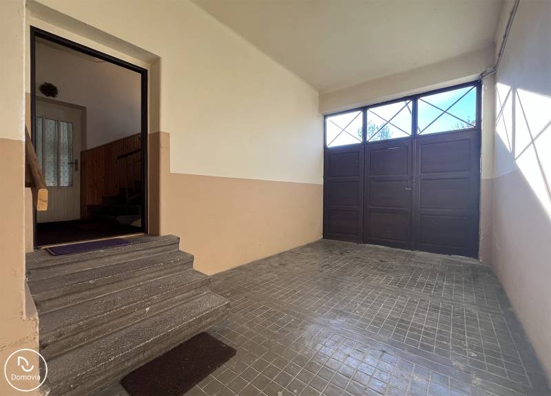 Eingangsbereich mit Garagentor in einer Wohnung mit 5 oder mehr Zimmern, Treppen führen ins Innere.