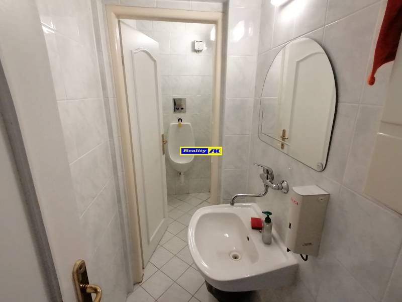 Kleines Badezimmer mit Waschbecken und Urinal in Büros.