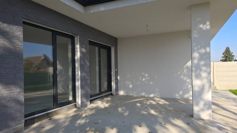 Die Terrasse eines Einfamilienhauses in Piešťany mit großen Fenstern und Steindekor.