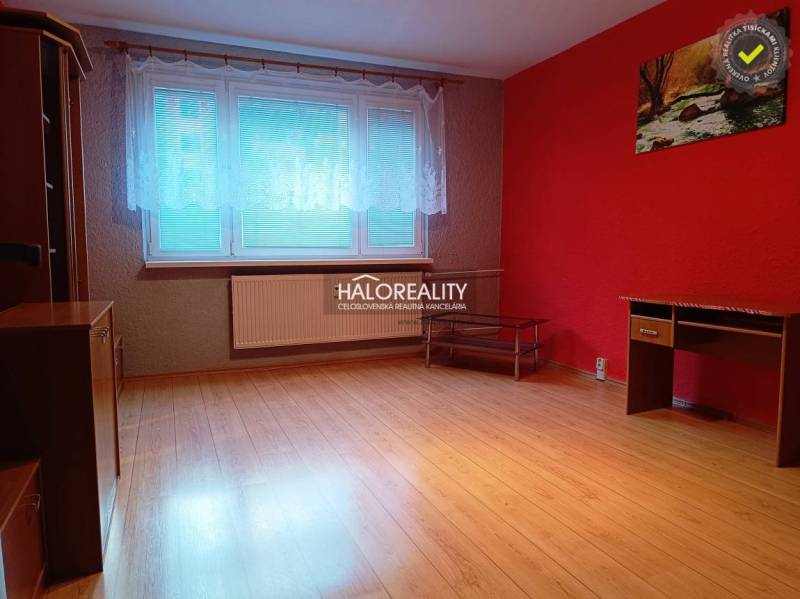 Innenraum einer 3-Zimmer-Wohnung mit roter Wand und Boden in Holzoptik.