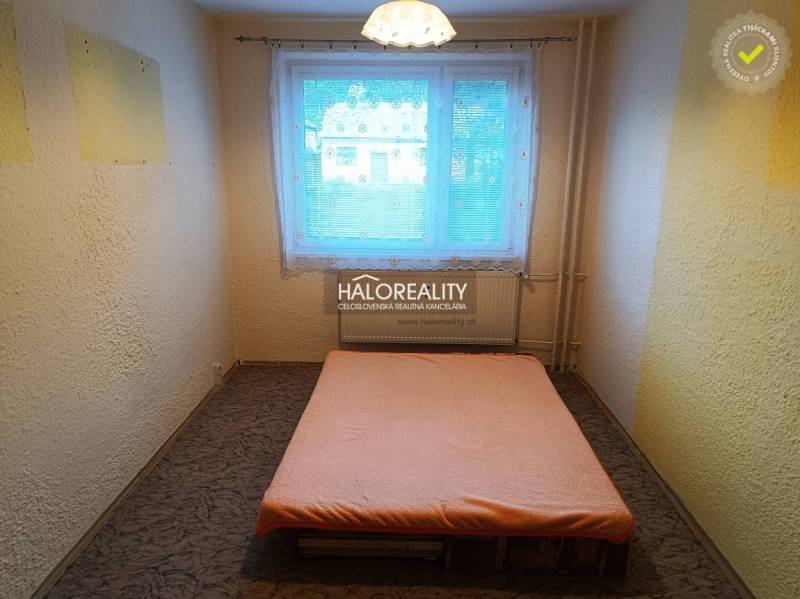 Einfaches Schlafzimmer mit Bett und Fenster in einer 3-Zimmer-Wohnung.