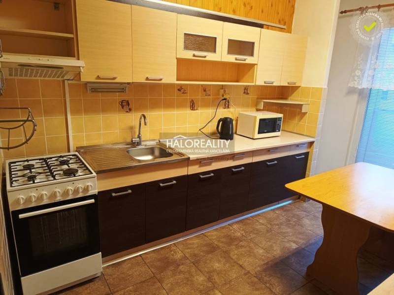 Küche in einer 3-Zimmer-Wohnung mit einem Gasherd und einem Boden in Holzoptik.