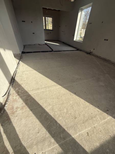 Innenraum eines Einfamilienhauses mit Betonboden und großen Fenstern in Most pri Bratislave.