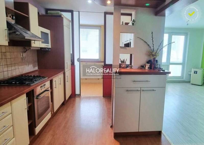 Küche in einem Studio-Apartment mit Holzboden und hellem Interieur.