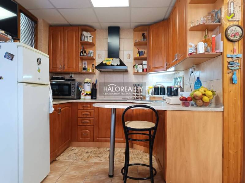 Eine Küche in einer Hütte mit Holzeinrichtung, Bartresen und Geräten.