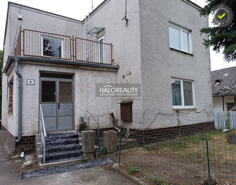 Ein Einfamilienhaus in Zemplín mit Treppe, Balkon und einem dünnen Zaun.
