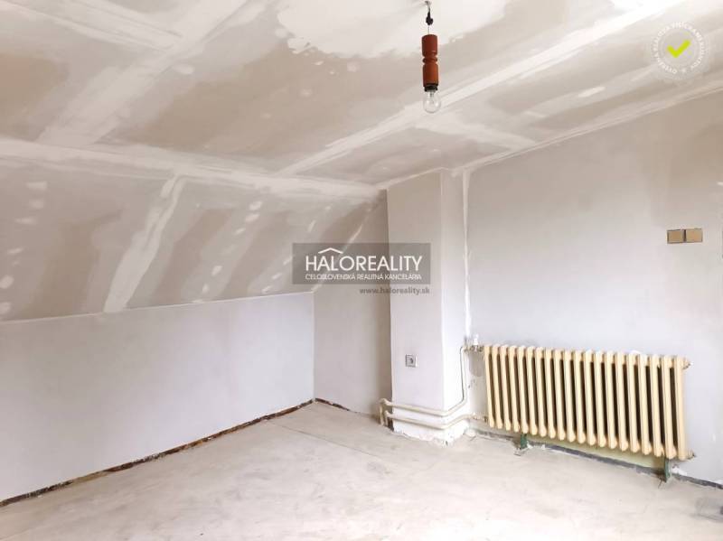 Ein Interieur mit weißer Decke, Heizkörper und Boden in einem Einfamilienhaus.