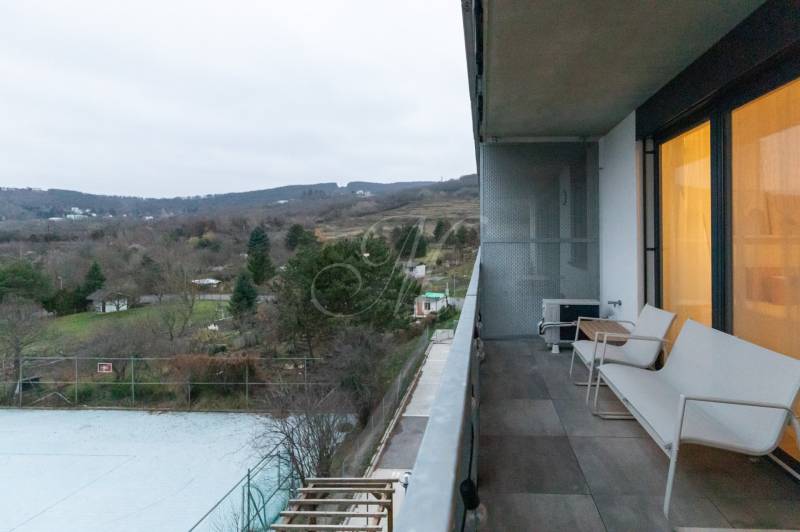 Balkon in einer Einzimmerwohnung, Blick auf die Natur, Aussicht auf Gärten und Bäume.