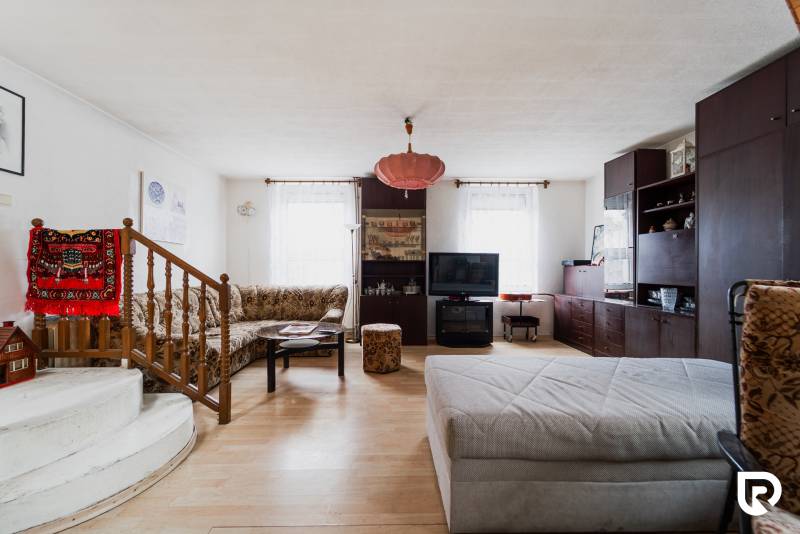 Wohnzimmer in einem Einfamilienhaus mit Holzboden und bequemen Sitzgelegenheiten.