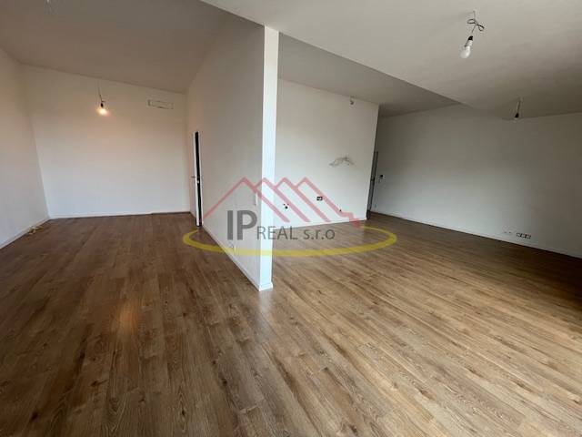 Ein Zimmer in einer 2-Zimmer-Wohnung mit einem Holzboden und weißen Wänden.