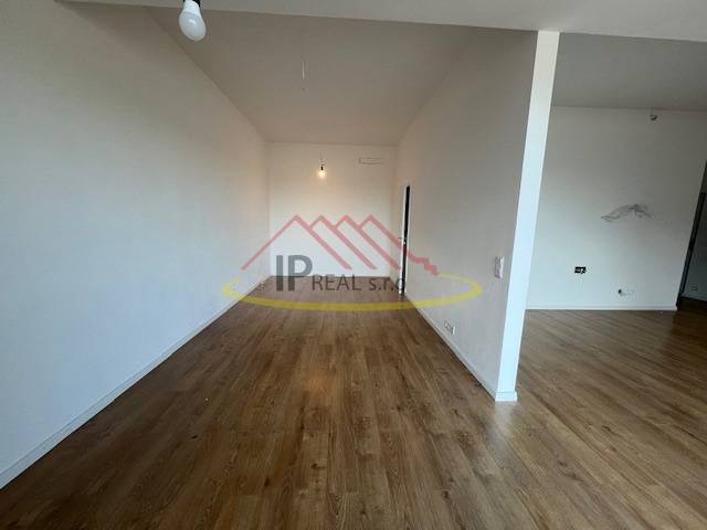 Ein Zimmer mit Holzboden in einer 2-Zimmer-Wohnung, neutrale Wände.