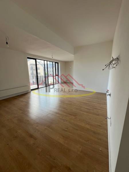 Innenraum einer 2-Zimmer-Wohnung mit Holzboden und großen Fenstern.