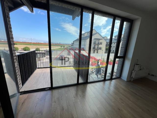 Innenraum einer 2-Zimmer-Wohnung mit großen Fenstern und einem Boden in Holzoptik.