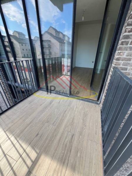 Balkon mit Holzboden in einer 2-Zimmer-Wohnung, mit Blick auf Gebäude.