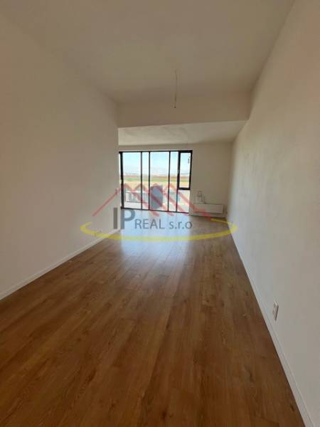 Helles Zimmer mit Holzboden in einer 2-Zimmer-Wohnung.