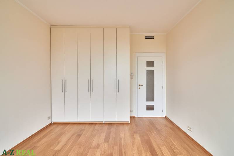 Helles Zimmer mit Holzboden und weißen Einbauschränken in einer 3-Zimmer-Wohnung.