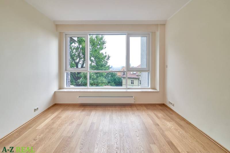 Ein Zimmer mit großem Fenster und Holzboden in einer 3-Zimmer-Wohnung.
