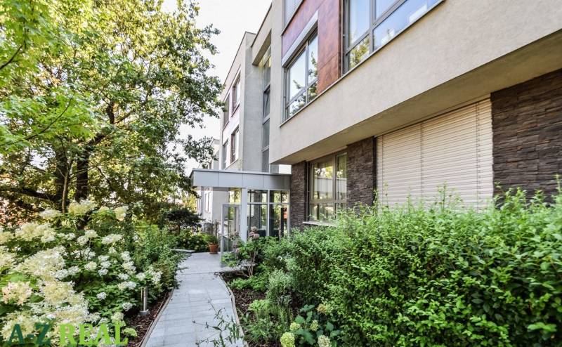 Ein Wohnhaus in der Mudroňova-Straße in Bratislava - Altstadt, umgeben von Grünflächen und einem Garten.