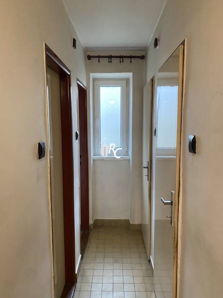 Ein enger Flur in einer 2-Zimmer-Wohnung mit hellem Bodenbelag.