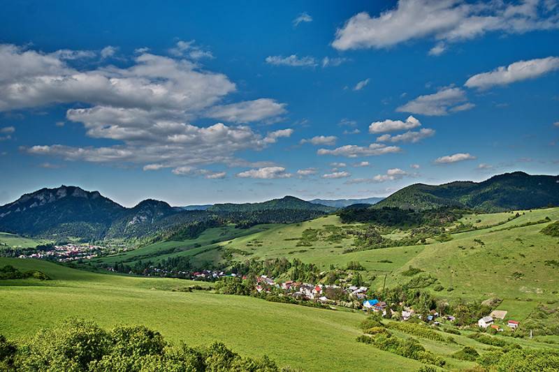 Schöne Landschaft in der Umgebung von Lechnice mit landwirtschaftlichen und forstwirtschaftlichen Flächen unter blauem Himmel.
