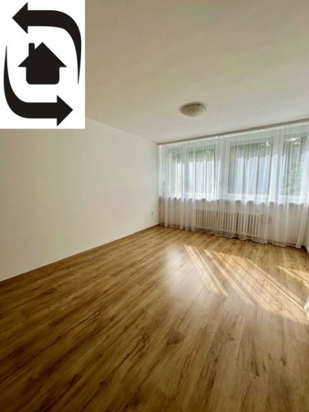 Helles Zimmer mit Vorhängen und Holzboden in einer 3-Zimmer-Wohnung.