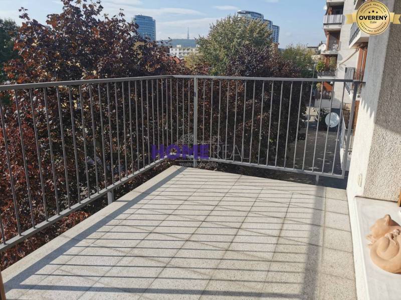 Der Balkon einer 2-Zimmer-Wohnung in der Drieňová-Straße in Bratislava - Ružinov mit Grün im Hintergrund.