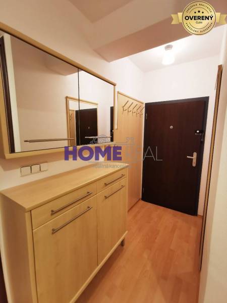 Der Flur in der 2-Zimmer-Wohnung mit einem Boden in Holzoptik, einem Spiegel und einem Schrank.