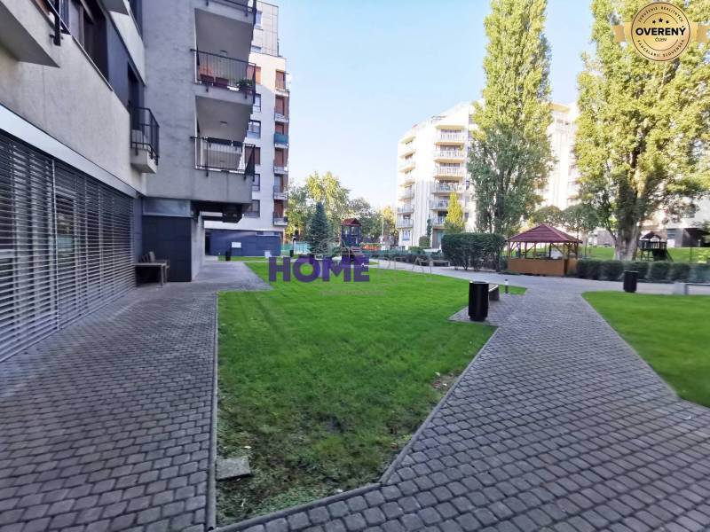 Ein Blick auf eine Wohngegend mit Gehweg und grünen Rasenflächen in Bratislava auf der Drieňová.