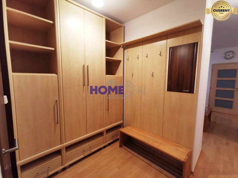 Eingangsbereich in einer 2-Zimmer-Wohnung mit Holzmöbeln und Spiegel.