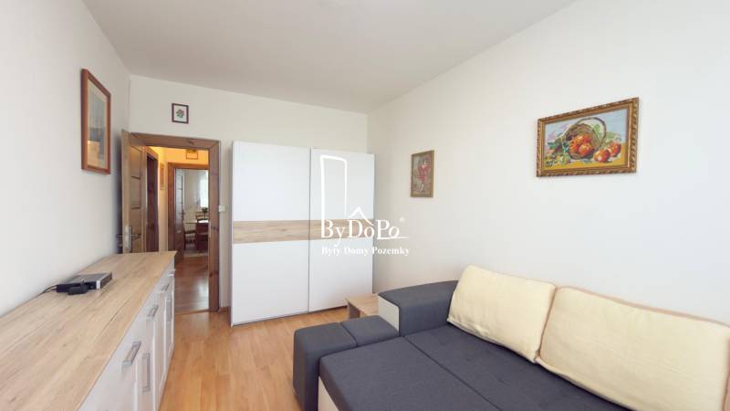 Wohnzimmer mit Sofa, Schrank und Holzboden in einer 3-Zimmer-Wohnung.