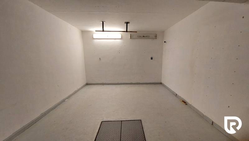 Ein geräumiger Raum mit weißen Wänden und heller Beleuchtung in einer 3-Zimmer-Wohnung.