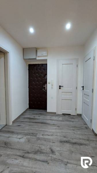 Eingangsbereich in einer 3-Zimmer-Wohnung mit Holzboden und weißen Türen.