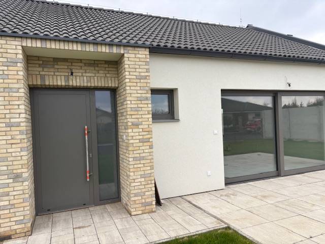 Einfamilienhaus in der Fialkova in Tomášov mit Ziegelverkleidung und geräumigen Glastüren.