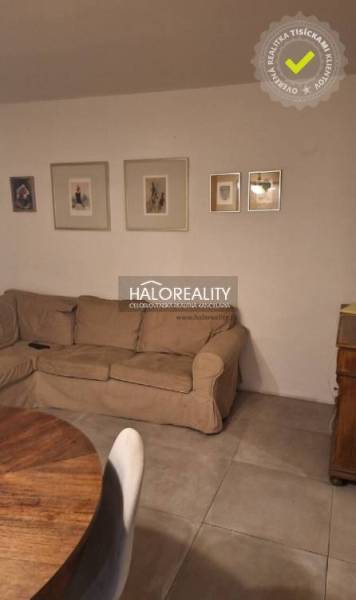 Wohnzimmer in einer 3-Zimmer-Wohnung mit Sofa, Holzboden und dekorativen Bildern.