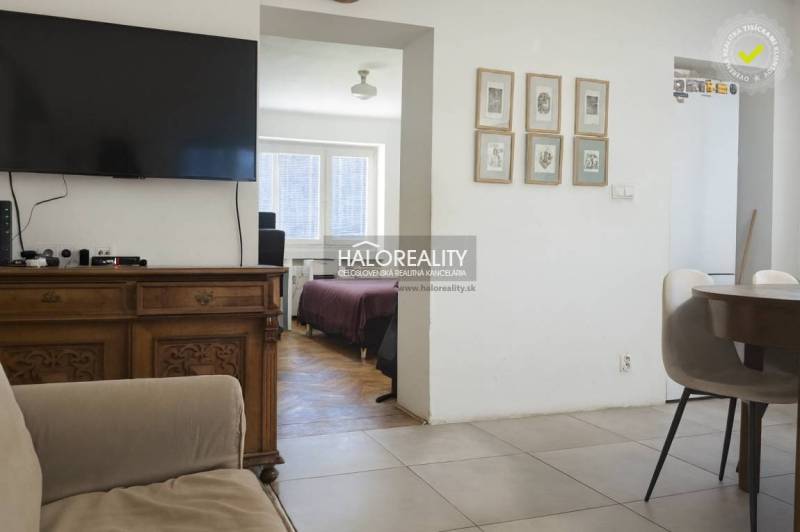 Wohnzimmer mit Fernseher, Stühlen und Blick auf das Schlafzimmer in einer 3-Zimmer-Wohnung.