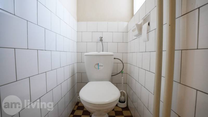 Toilette mit Fliesen und Bodenbelag in einem Einfamilienhaus.