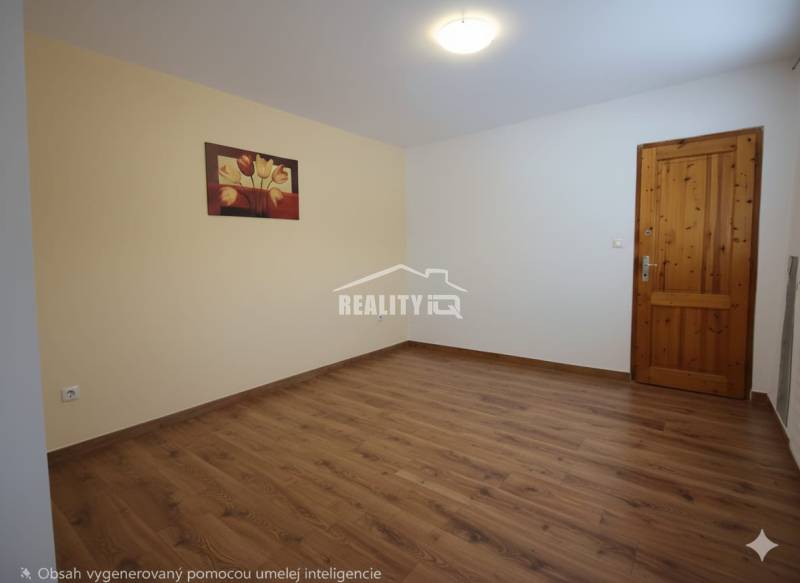 Ein Zimmer mit einem Holzboden, einem Bild an der Wand und Holztüren.