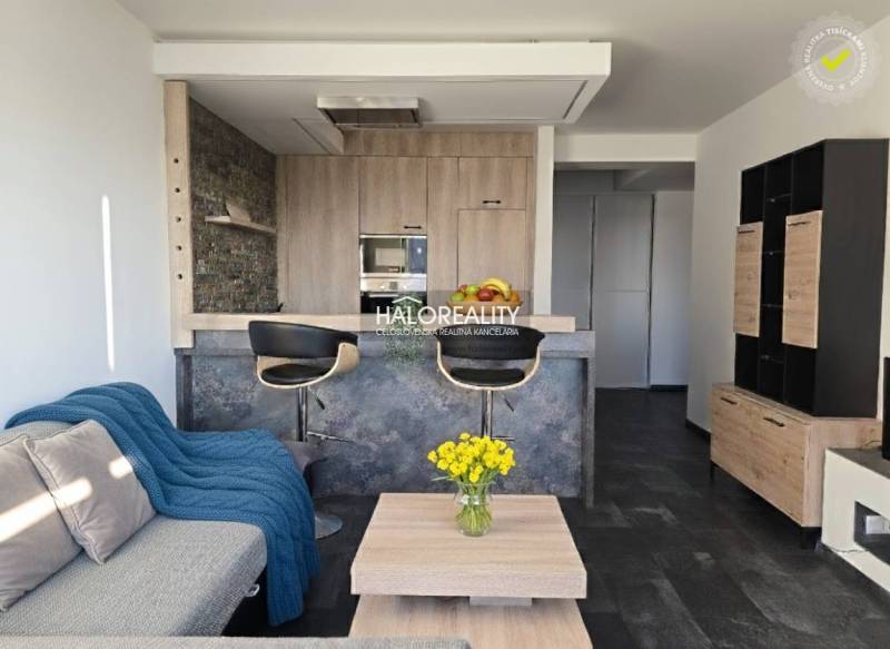 Wohnzimmer in einer 2-Zimmer-Wohnung mit offener Küche und Holzboden.