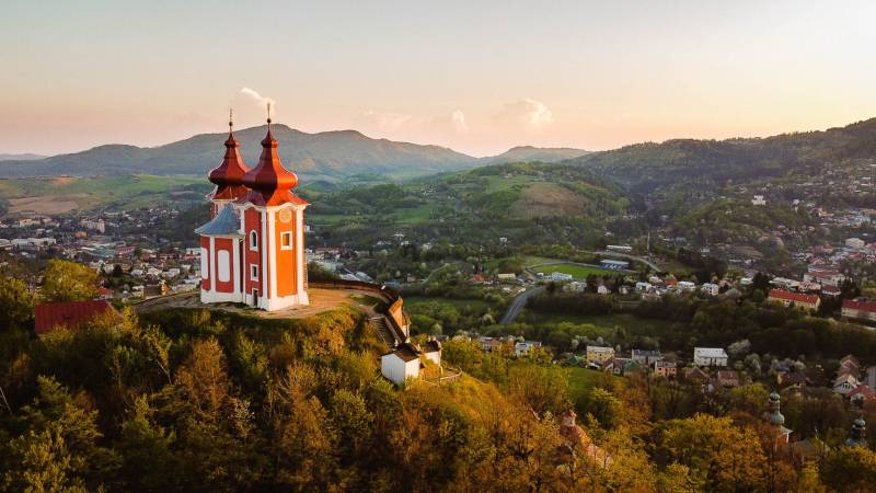 Kalvarienberg auf dem Hügel mit Panorama von Banská Štiavnica, umgeben von landwirtschaftlichen und forstwirtschaftlichen Flächen.