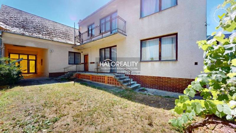 Einfamilienhaus in Malacky mit Balkon, Treppe und Garten, dazu gehört ein Unterstand.