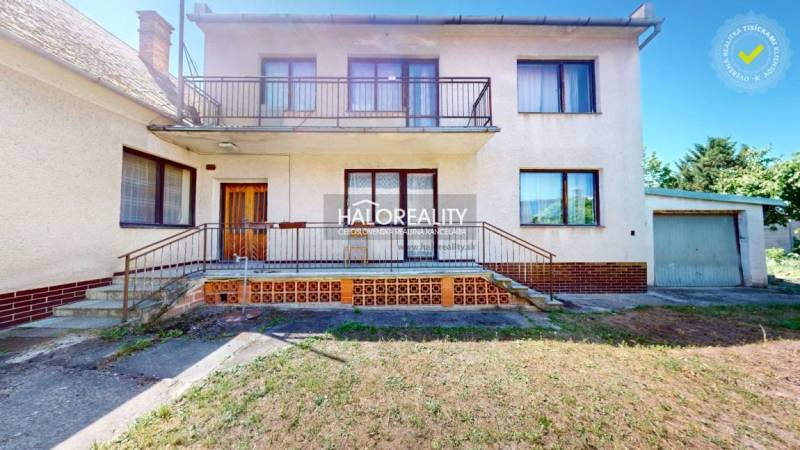 Einfamilienhaus in Malacky mit Balkon und Garage, umgeben von einem Garten.
