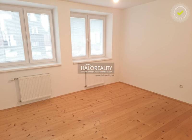 Ein Zimmer in einem Einfamilienhaus mit einem Boden in Holzoptik und weißen Wänden.