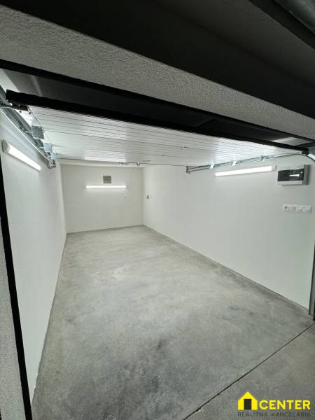 Geräumiges Garageninnere mit Betonboden und weißen Wänden.