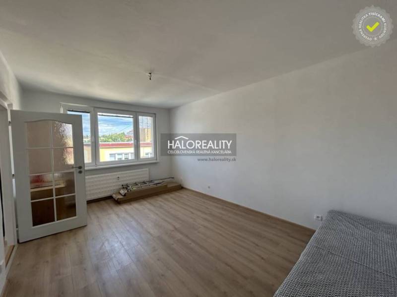 Helles Zimmer mit Holzboden in einer Einzimmerwohnung.