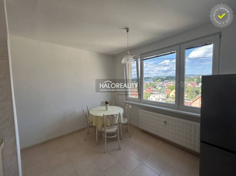 Küche in einer Einzimmerwohnung mit Blick auf die Stadt und Sitzgelegenheit am Tisch.