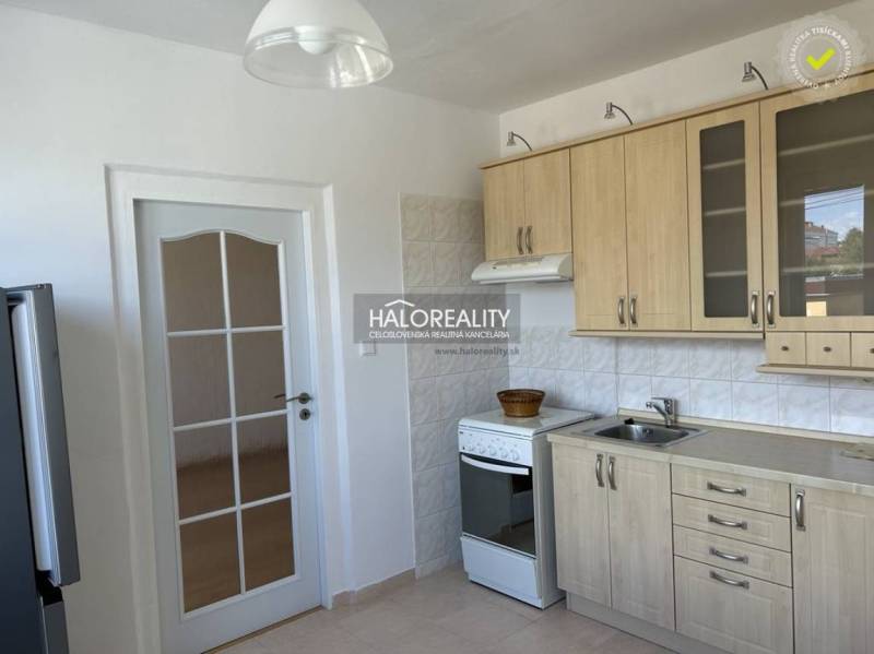 Küche mit Holzdekor, geflieste Wand, weißer Herd und weiße Türen.