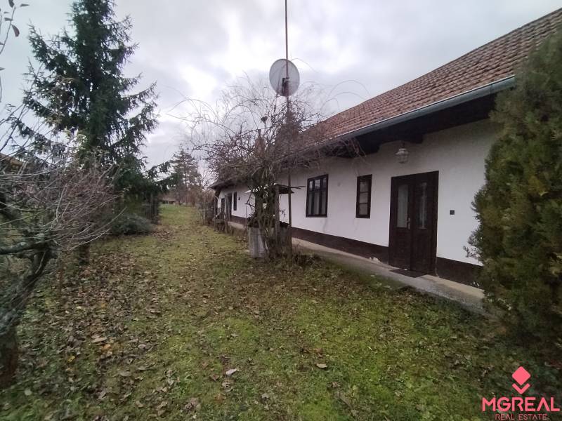 Ein Einfamilienhaus in Dolný Pialy mit Rasen und Bäumen im Hof.